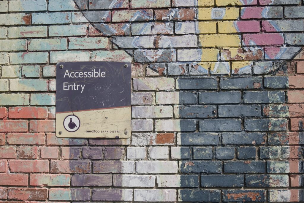 A non-useful accessible entry sign on brick wall